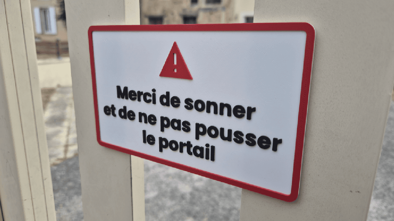 Made-to-measure signage plaque with raised text, warning symbol and red frame, close-up view